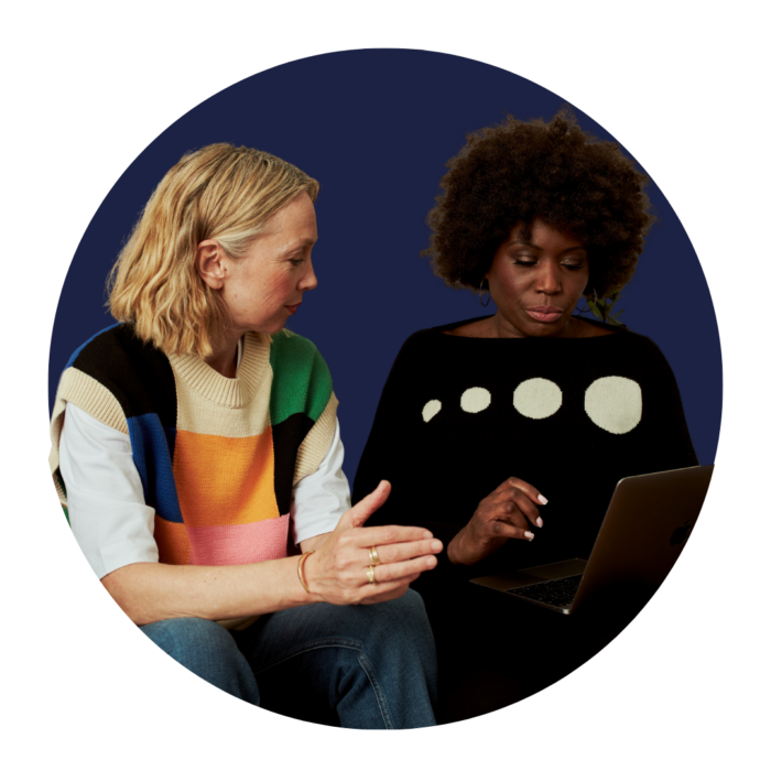 Two colleagues looking at a laptop.