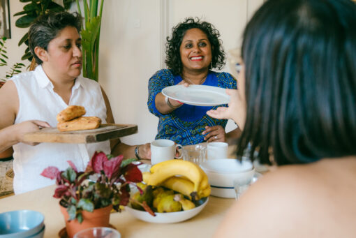 A group of adults passing plates around a dinner table.