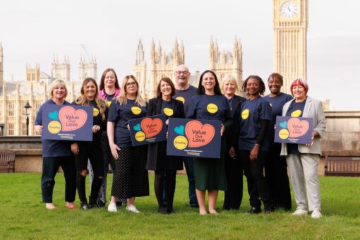 A group of Kinship campaigners standing outside Parliament holding placards that say 