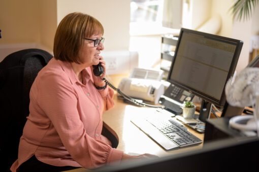 woman on the phone sat at a computer