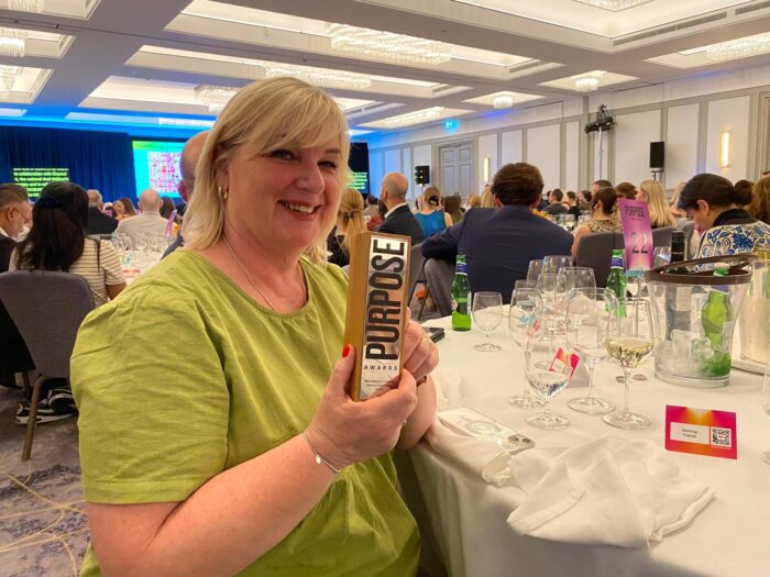 Kinship team member Janice Santos holding Kinship's Purpose Award for Best Advocacy Campaign 2025